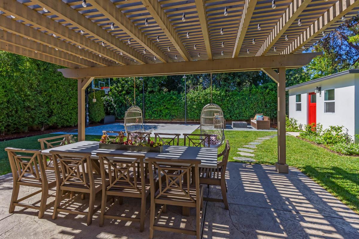 1489 Brookmill Road Los Altos, CA 94024 - Photo 26 of 43 a view of a patio with table and chairs a barbeque with wooden floor and roof with a garden view