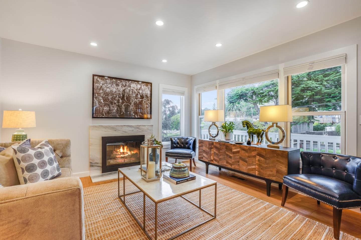 a living room with furniture a fireplace and a floor to ceiling window