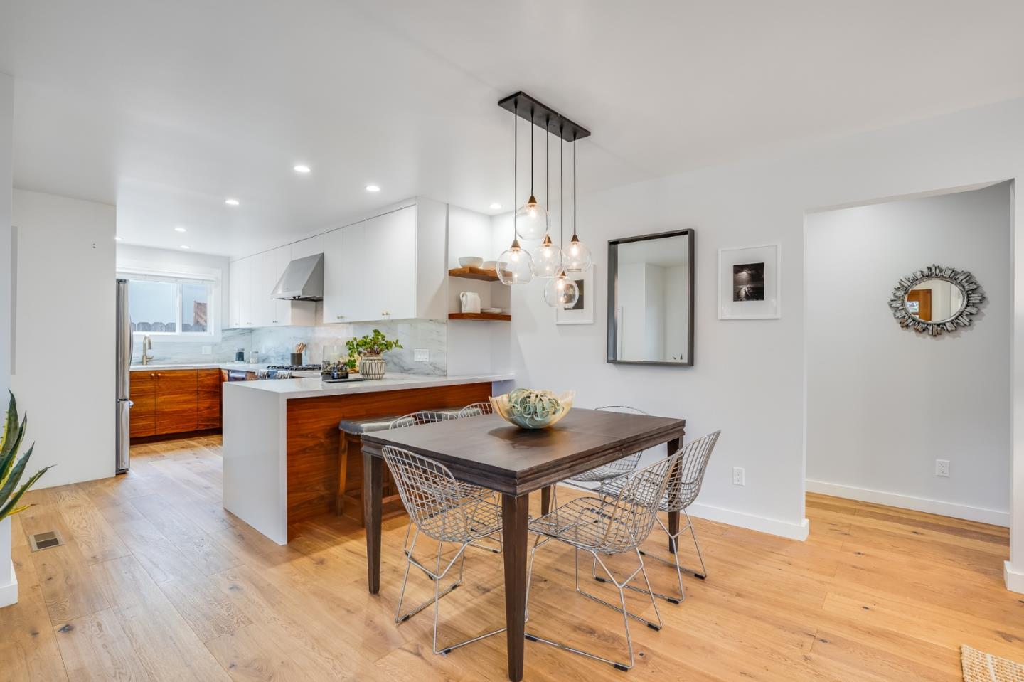 646 Brighton Road Pacifica, CA 94044 - Photo 5 of 26 a kitchen with stainless steel appliances kitchen island granite countertop a refrigerator a stove a sink dishwasher and white cabinets with wooden floor