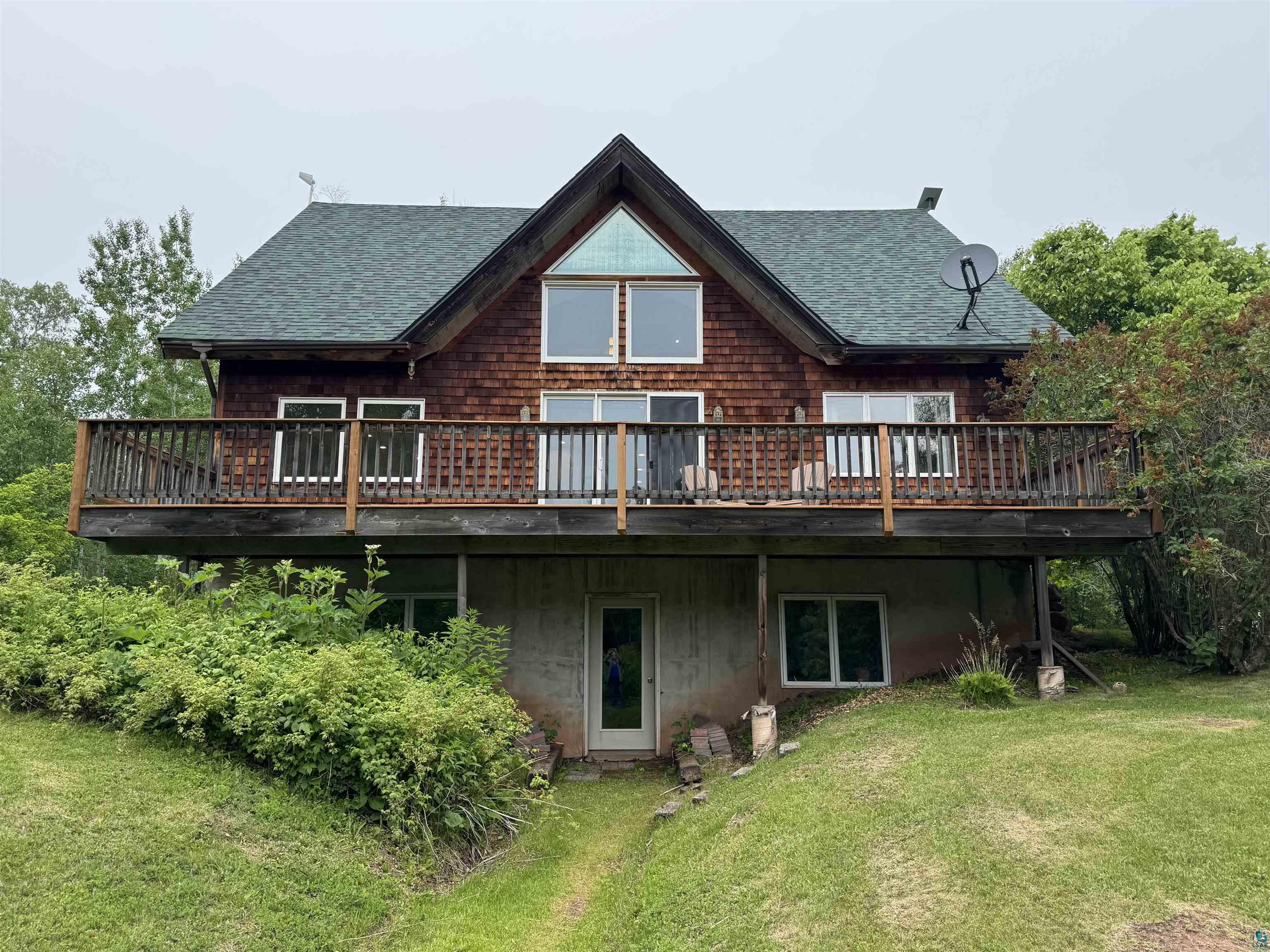 Wood-sided multi-level home with a steep-pitched asphalt shingle roof
