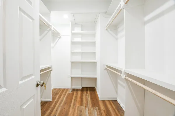 a view of walk in closet with empty racks