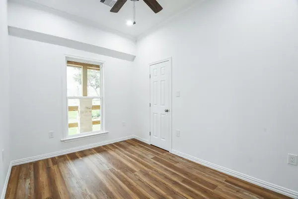 an empty room with a window and wooden floor