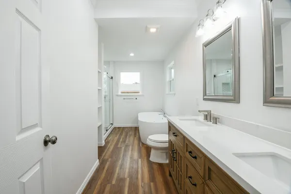 a bathroom with a double vanity sink toilet and shower