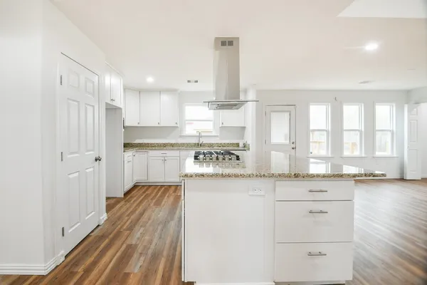 a kitchen with granite countertop white cabinets and white appliances