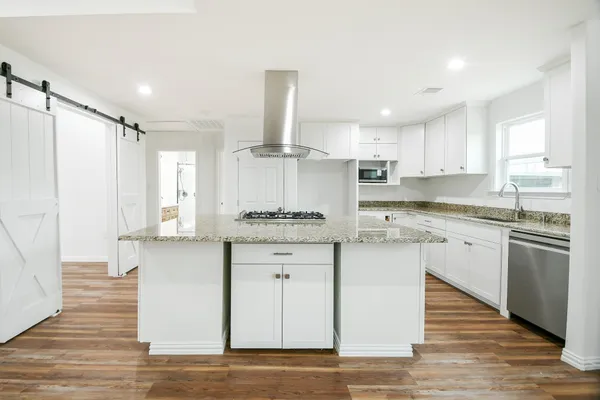 a kitchen with granite countertop white cabinets and white appliances