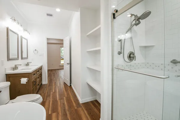 a bathroom with a sink a toilet and shower