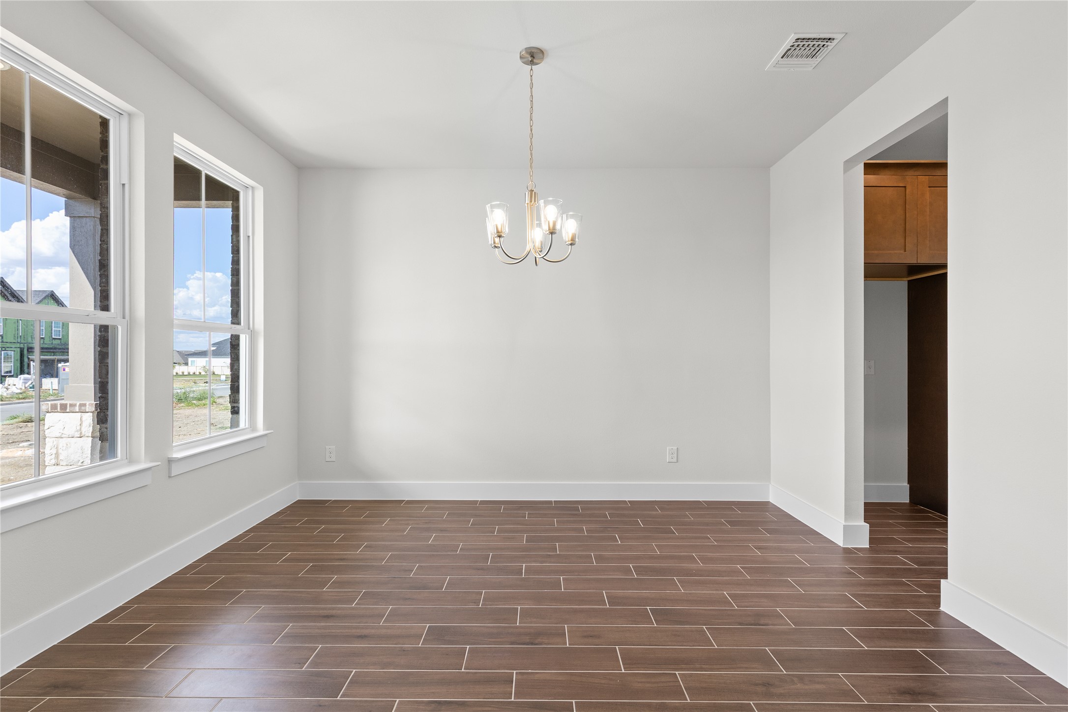 19705 Domino Champ Road Pflugerville, TX 78660 - Photo 7 of 38 Rich tile flooring and a classic chandelier anchor this versatile, light-filled dining space.