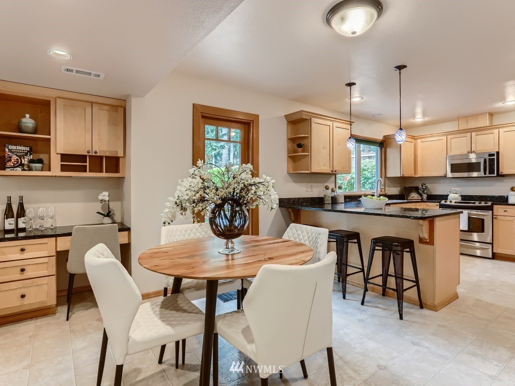 23630 3rd Place West Bothell, WA 98021 - Photo 12 of 28 a kitchen with stainless steel appliances kitchen island granite countertop a dining table chairs and a refrigerator