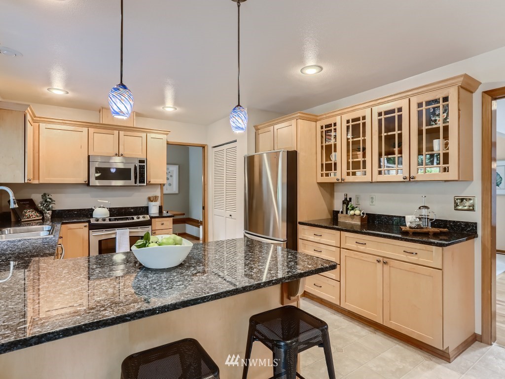 23630 3rd Place West Bothell, WA 98021 - Photo 9 of 28 a kitchen with stainless steel appliances granite countertop a sink stove refrigerator dining table and chairs