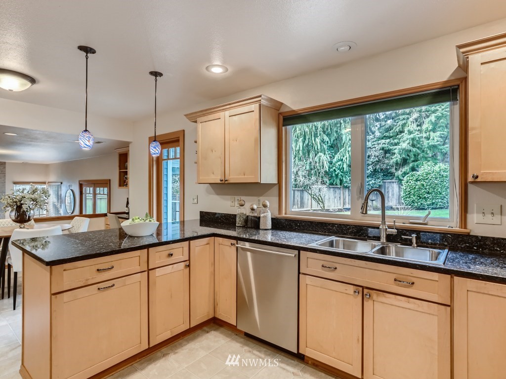 23630 3rd Place West Bothell, WA 98021 - Photo 10 of 28 a kitchen with granite countertop a sink and white cabinets