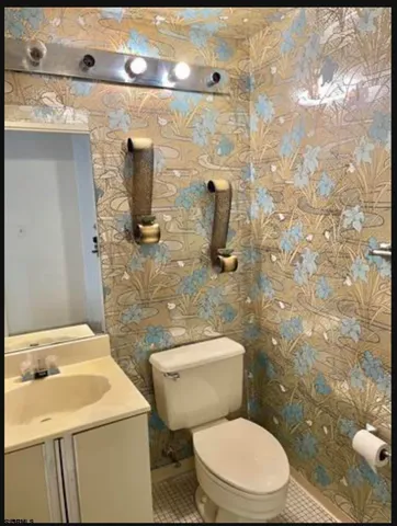 a white toilet sitting next to a bathroom sink