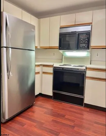 a kitchen with stainless steel appliances a stove microwave and refrigerator