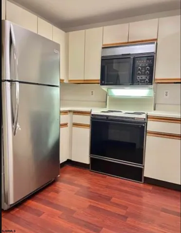a kitchen with stainless steel appliances a stove microwave and refrigerator
