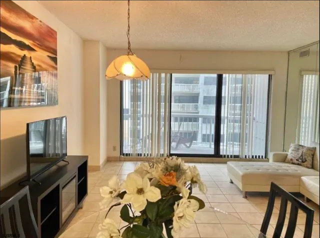 a spacious bedroom with a bed and a chandelier