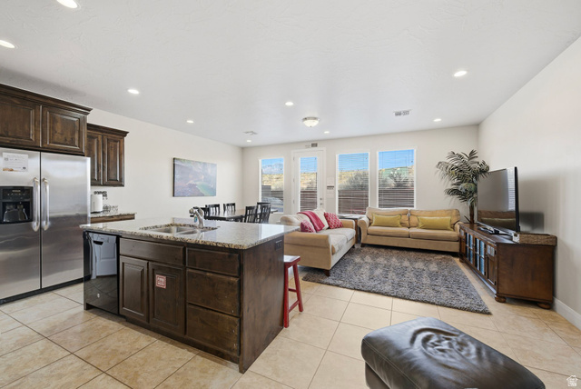 4269 Razor Drive Washington, UT 84780 - Photo 45 of 50 Kitchen featuring dark brown cabinetry, stainless steel fridge, open floor plan, an island with sink, and dishwasher