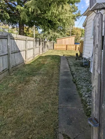 a view of a yard with wooden fence