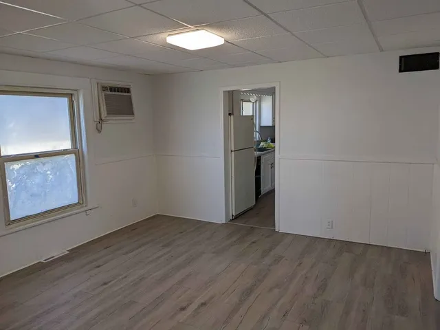 an empty room with wooden floor and mirror