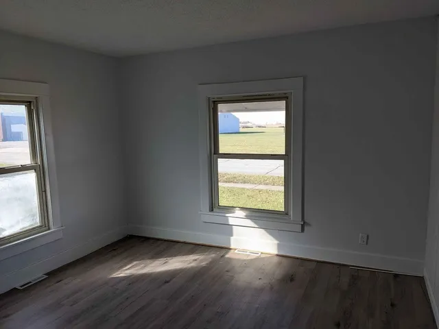an empty room with wooden floor and a window