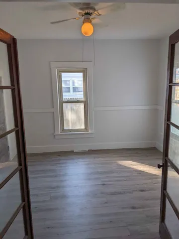 a view of a room with wooden floor and window