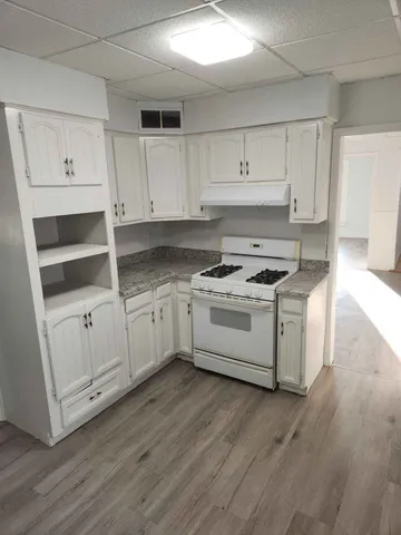 a kitchen with granite countertop white cabinets and white appliances