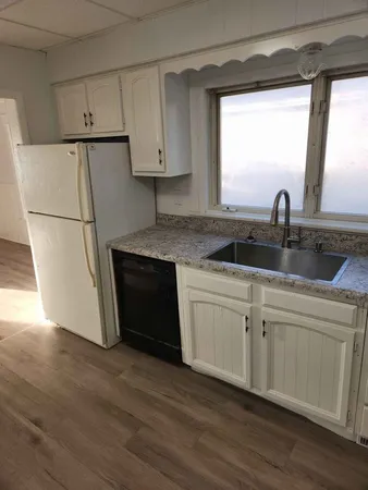 a kitchen with a refrigerator sink and cabinets