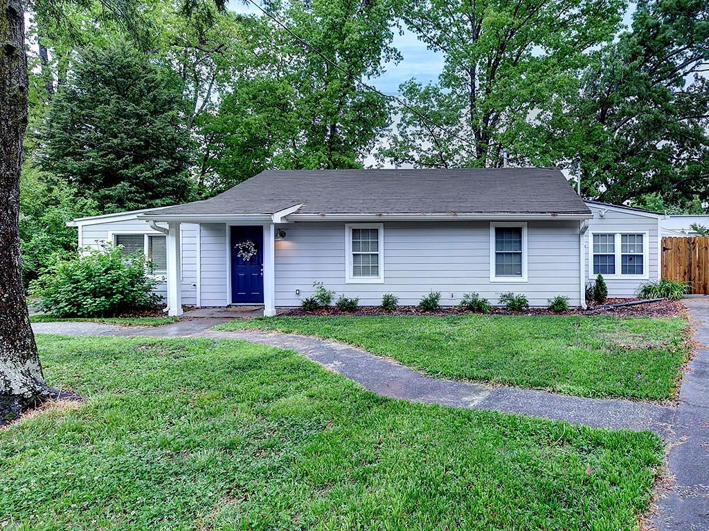 a front view of a house with a yard and trees