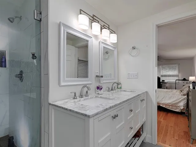 a en suite bathroom with a granite countertop sink and a mirror