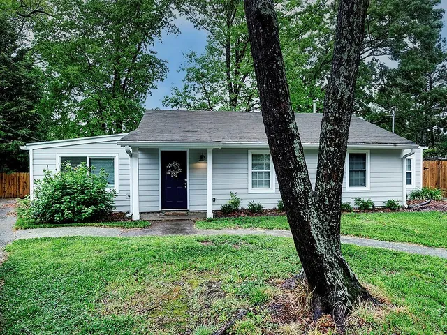 a front view of a house with a garden and yard