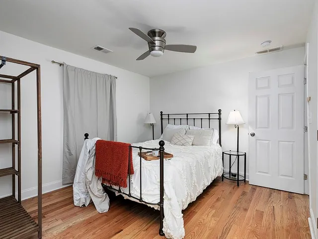 a bedroom with bed and wooden floor