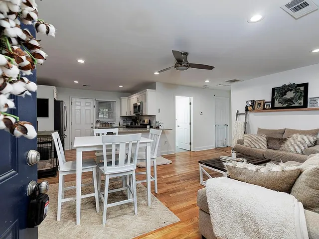 a living room with furniture a flat screen tv and a dining table