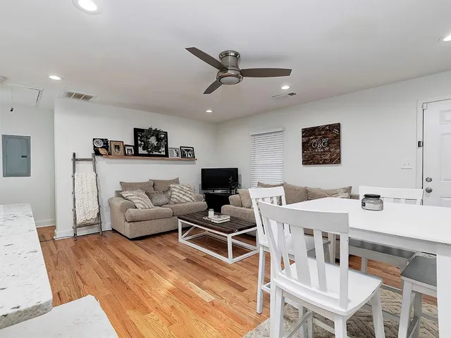 a living room with furniture a flat screen tv and a table