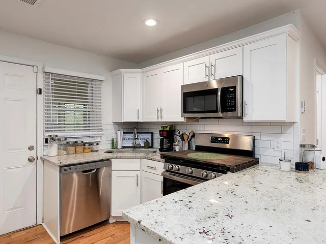a kitchen with stainless steel appliances a stove sink microwave and cabinets