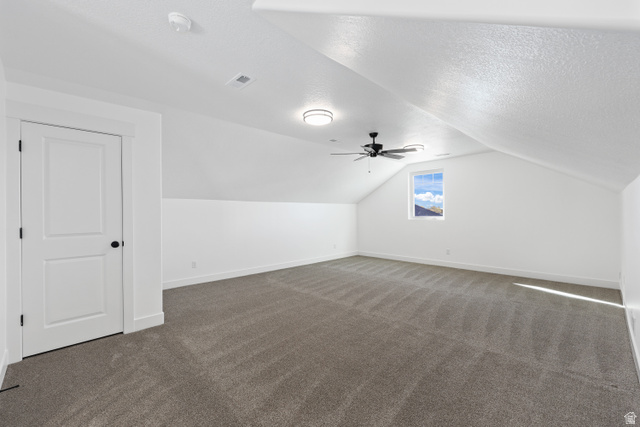 1139 South 4475 West West Point, UT 84015 - Photo 21 of 33 Additional living space with vaulted ceiling, dark carpet, a textured ceiling, and a ceiling fan