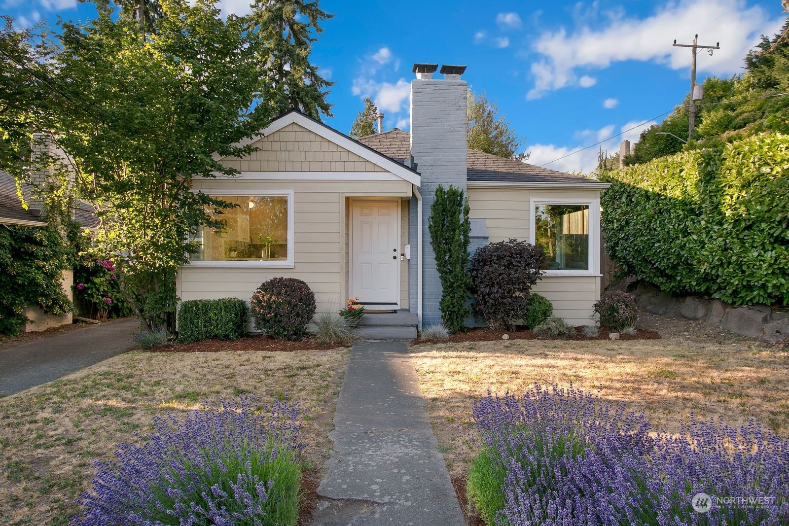 a front view of a house with a yard and potted plants