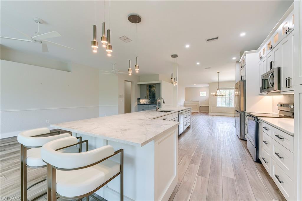 10751 Crooked River Road, Unit 202 Estero, FL 34135 - Photo 4 of 45 White Shaker Cabinetry with Lighted glass upper cabinetry above