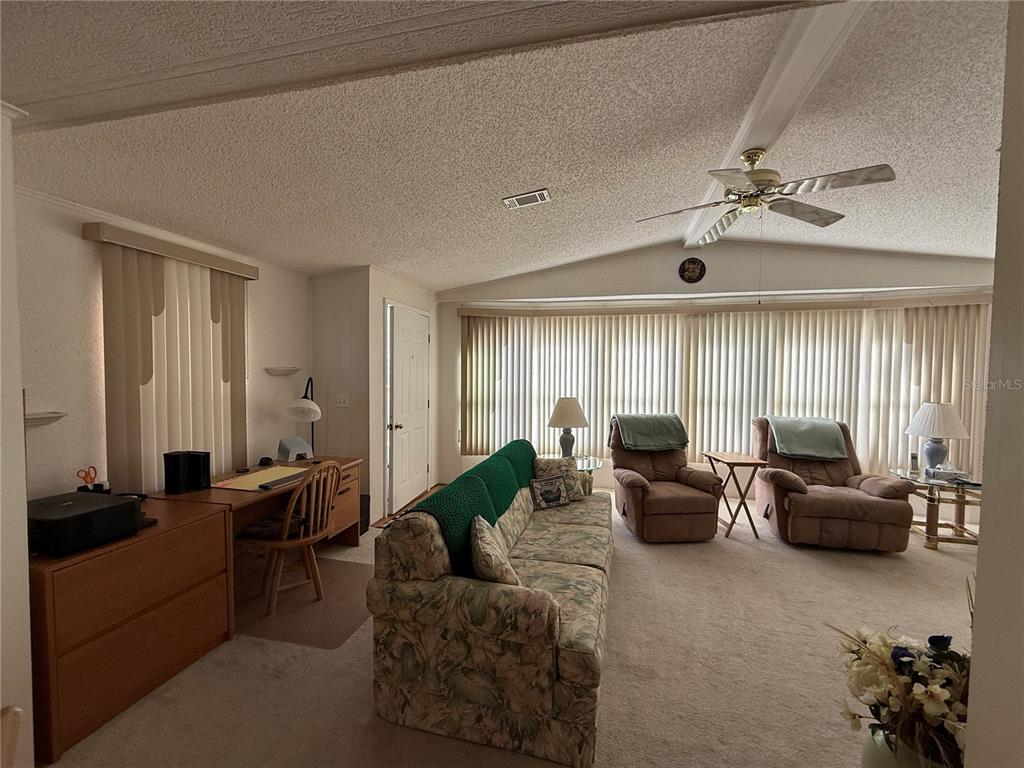 105 Cypress Road Wildwood, FL 34785 - Photo 12 of 26 a living room with furniture ceiling fan and a window