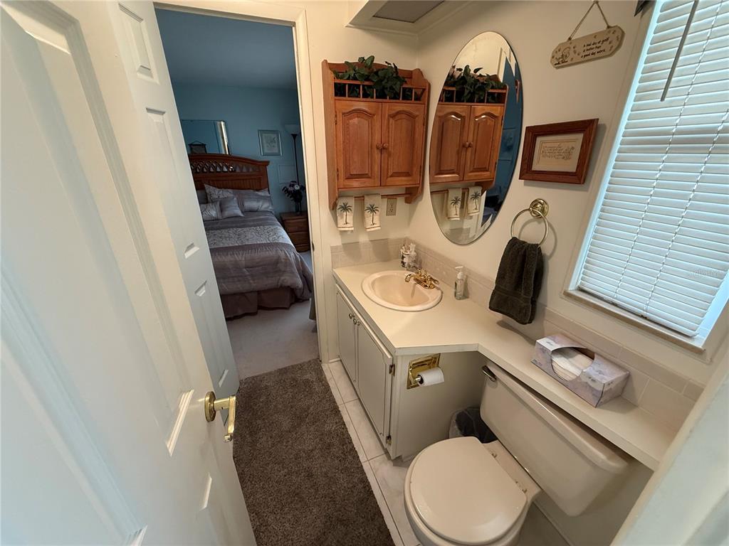 105 Cypress Road Wildwood, FL 34785 - Photo 14 of 26 a bathroom with a toilet sink and mirror