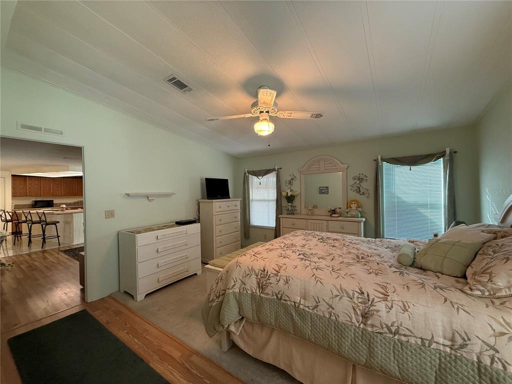 105 Cypress Road Wildwood, FL 34785 - Photo 17 of 26 a bedroom with a bed and a chandelier
