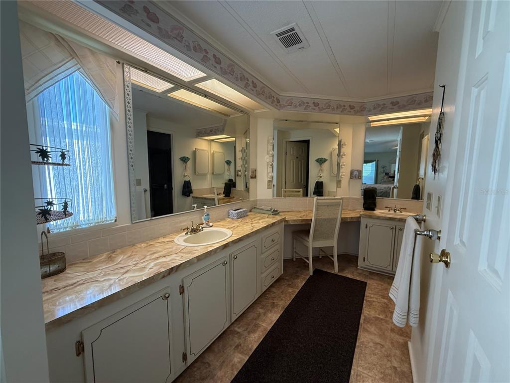 105 Cypress Road Wildwood, FL 34785 - Photo 21 of 26 a large bathroom with a double vanity sink and a mirror
