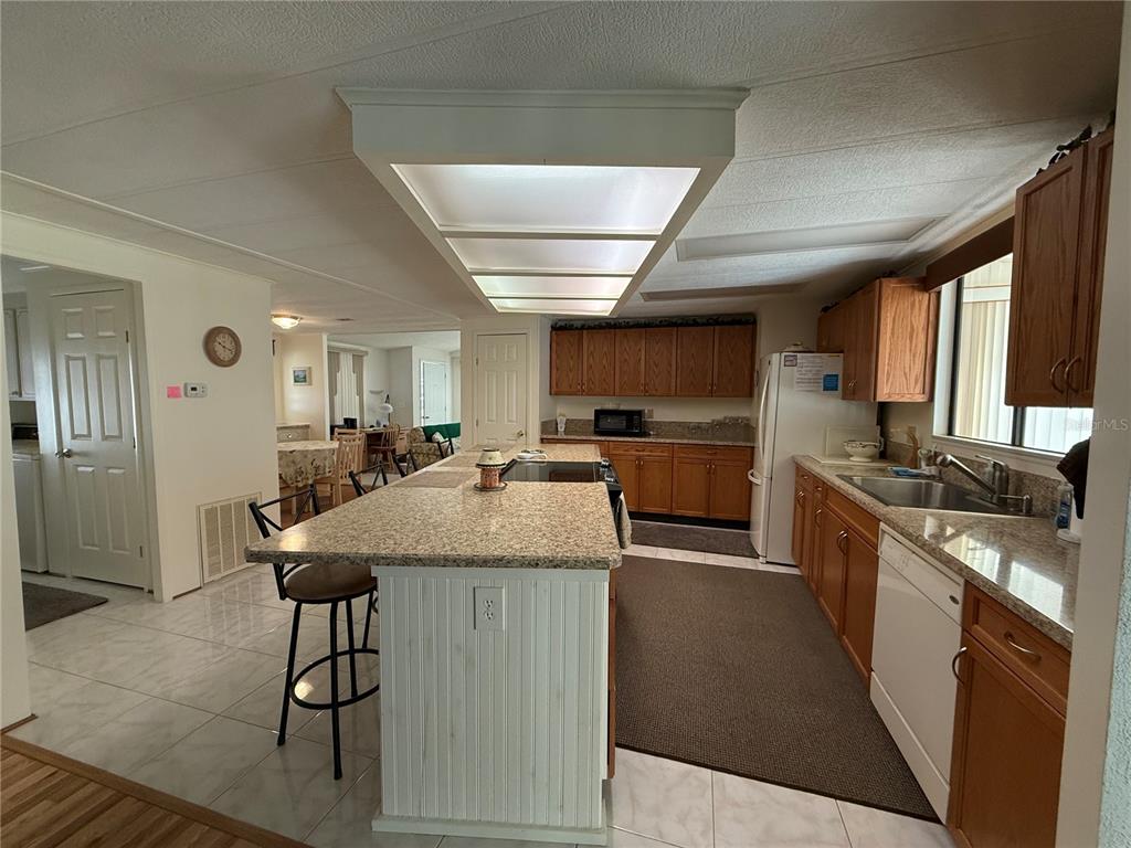 105 Cypress Road Wildwood, FL 34785 - Photo 5 of 26 a kitchen with stainless steel appliances granite countertop a sink a stove and a refrigerator