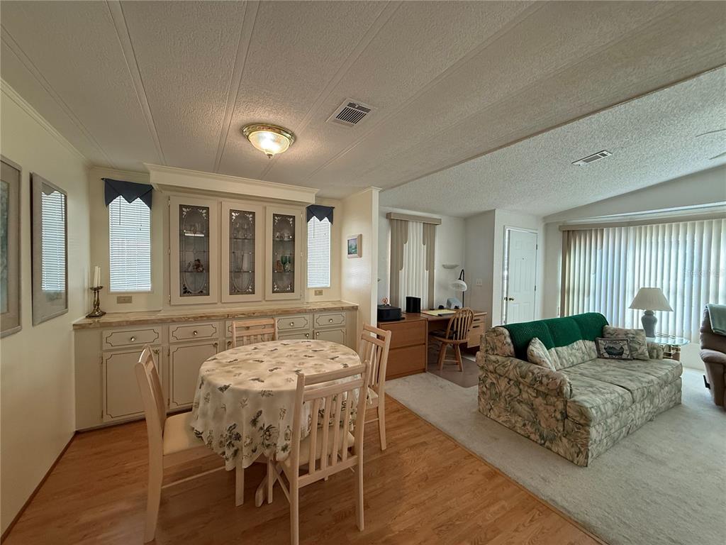 105 Cypress Road Wildwood, FL 34785 - Photo 7 of 26 a living room with furniture dining table and wooden floor