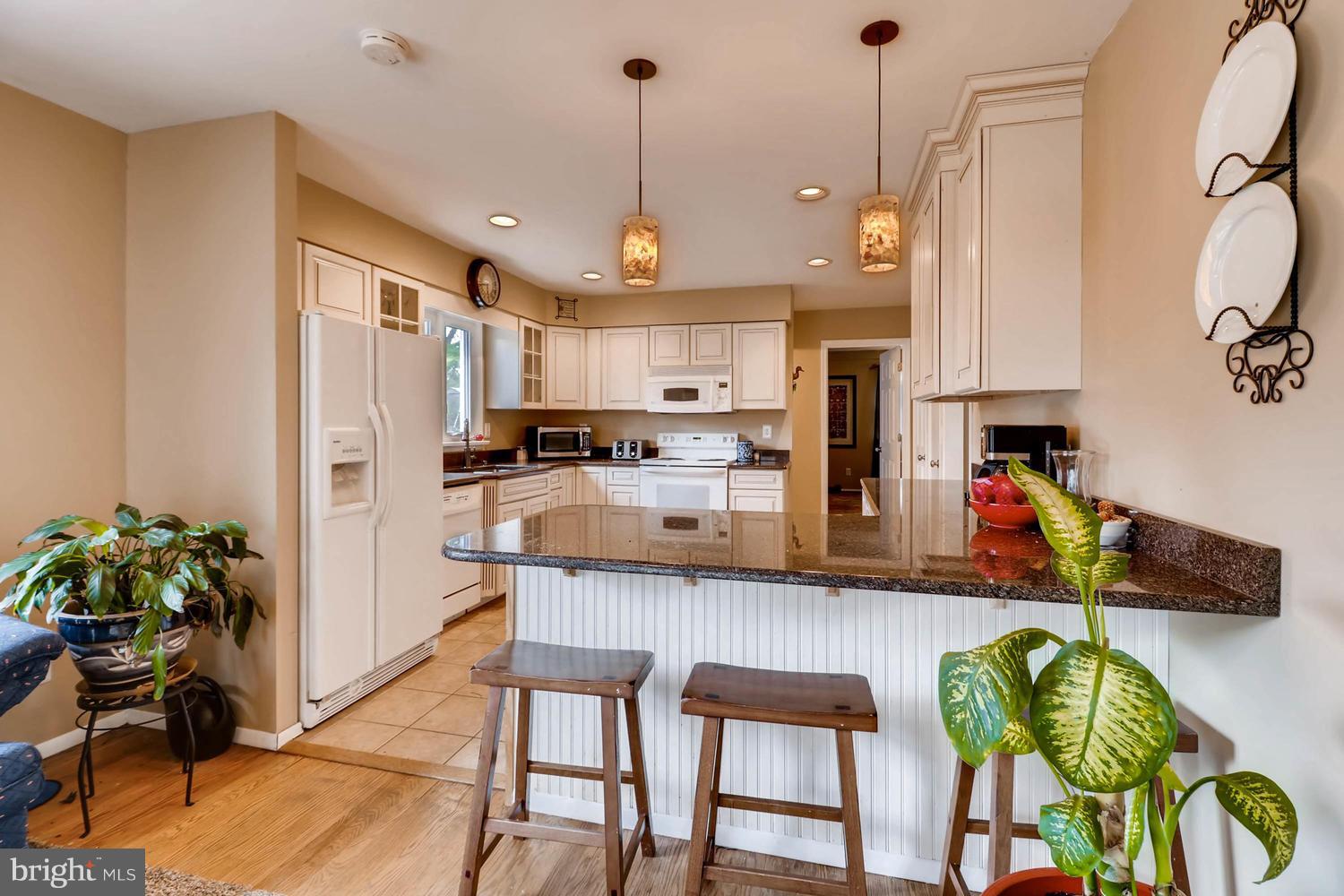 342 Old Joppa Road Fallston, MD 21047 - Photo 7 of 28 a kitchen with stainless steel appliances granite countertop a refrigerator a sink dishwasher a dining table and chairs with wooden floor