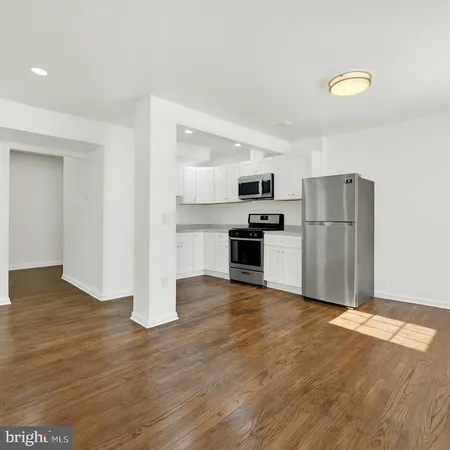 a kitchen with wooden floors and refrigerator