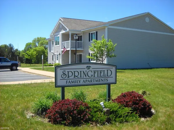 a view of sign board with buildings in the background