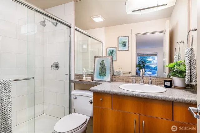 a bathroom with a granite countertop sink toilet and shower