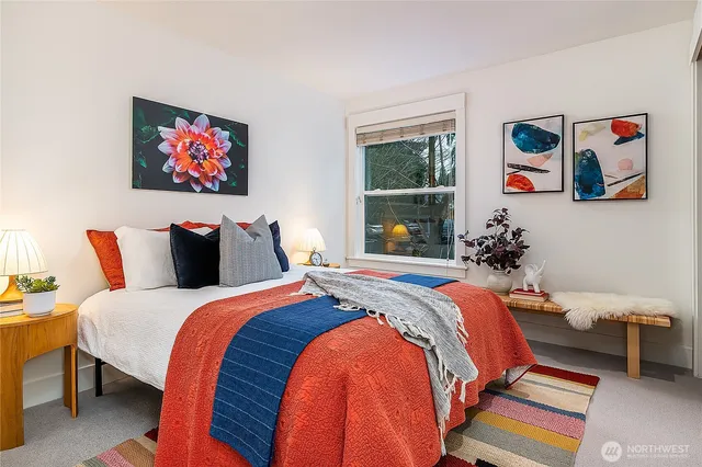 a bedroom with bed and a painting on the wall