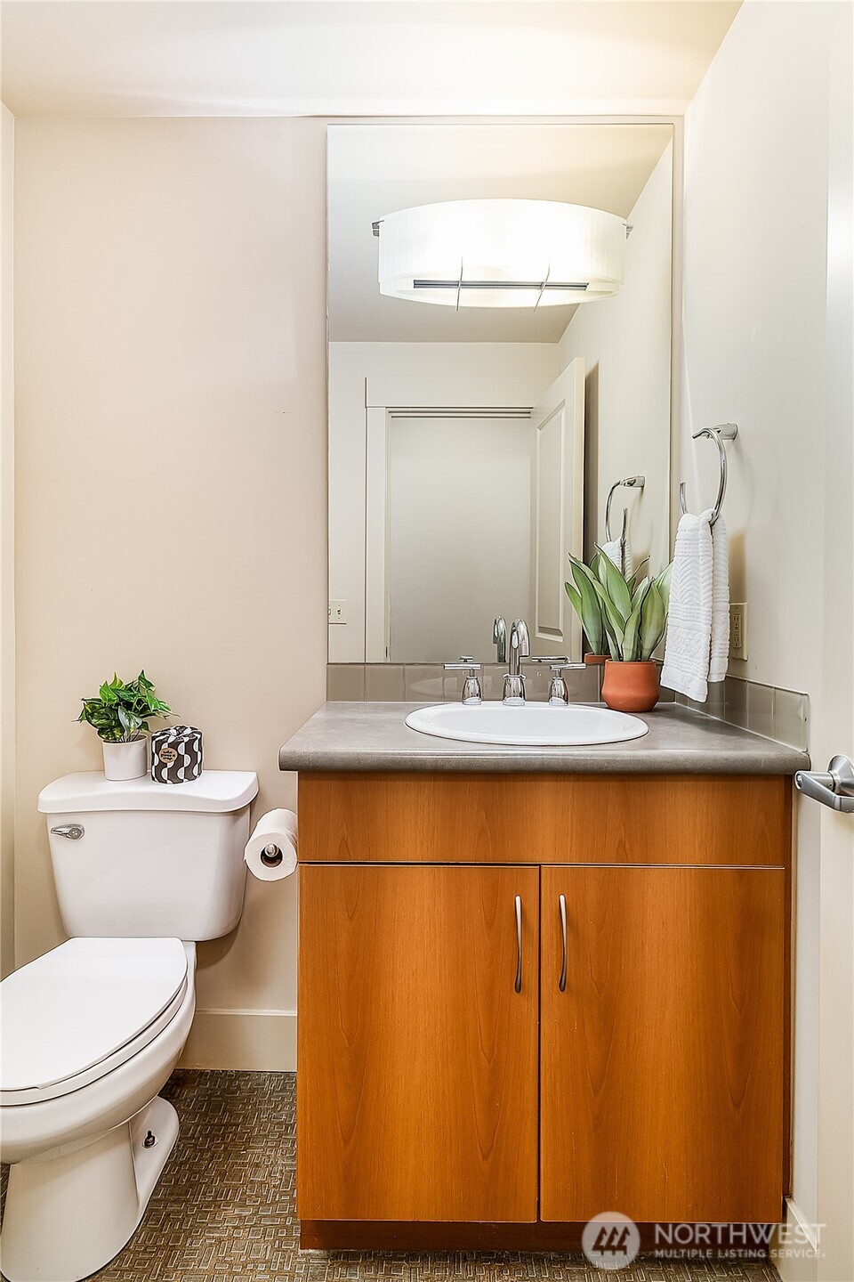 23015 Edmonds Way, Unit A214 Edmonds, WA 98020 - Photo 15 of 24 a bathroom with a sink a mirror and a toilet