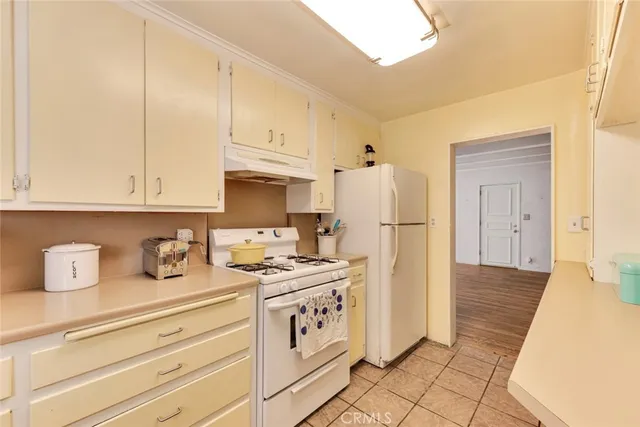 a kitchen with stainless steel appliances granite countertop a refrigerator sink and white cabinets