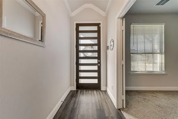a view of a room with a white door and wooden floor