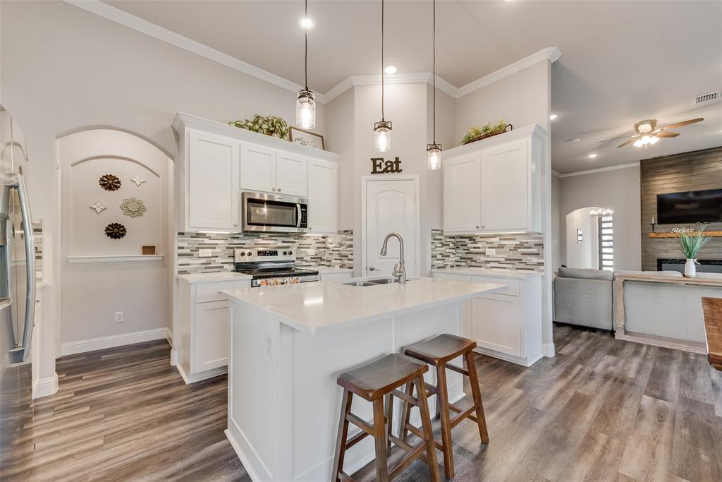 404 West Rochester Street Terrell, TX 75160 - Photo 4 of 24 a kitchen with stainless steel appliances a stove top oven a sink dishwasher and a refrigerator with wooden floor